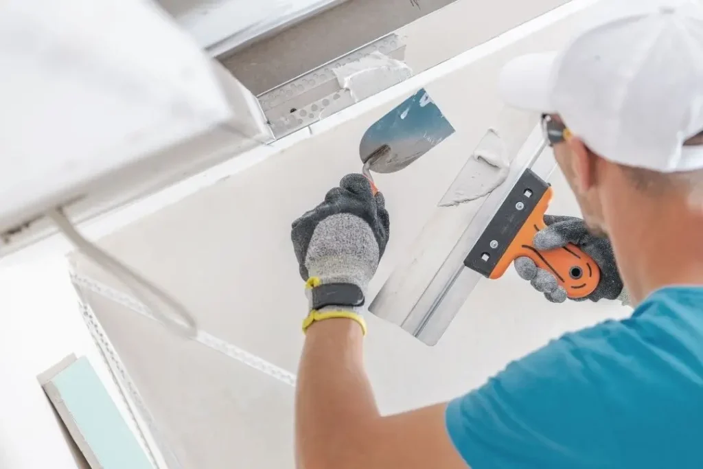 plasterer installing a plasterboard ceiling